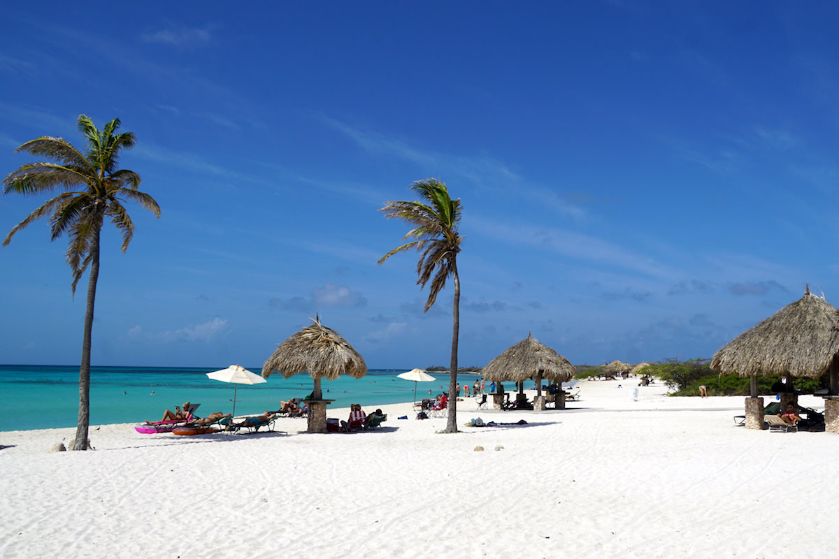 a picture of arashi beach aruba with beach huts looking north