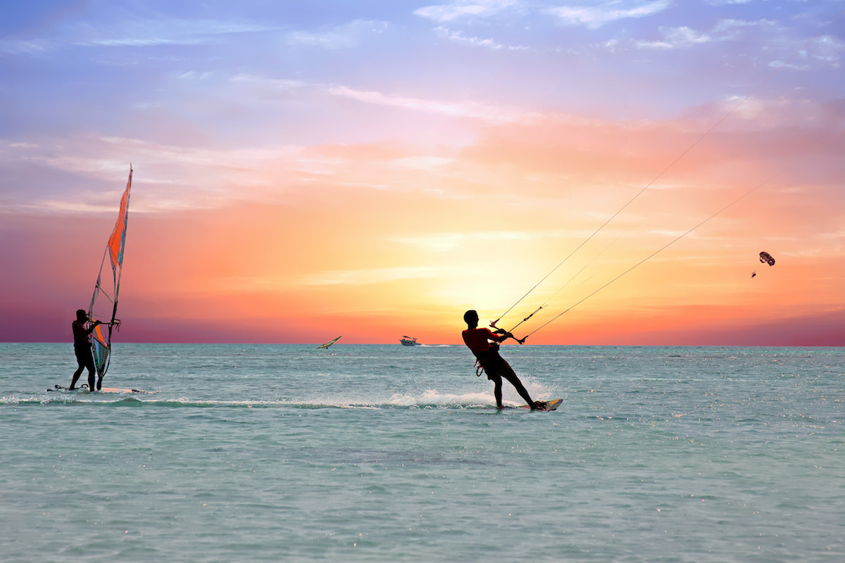 a picture of people kitesurfing and windsurfing at barcadera beach aruba