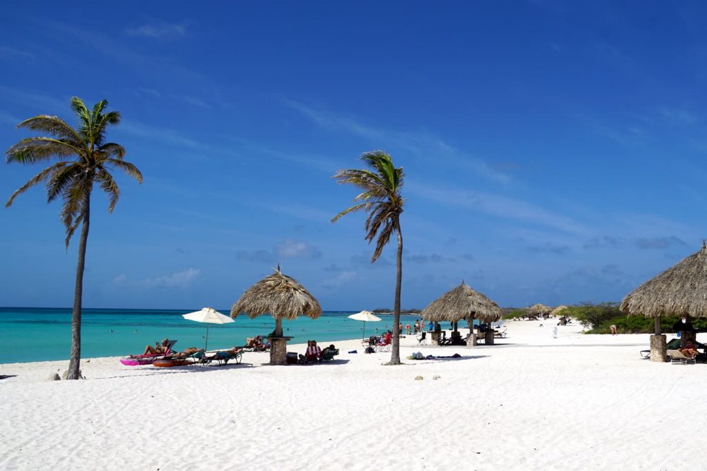 white sands with palm trees on Arashi Beach in Aruba, in the Dutch Caribbean.