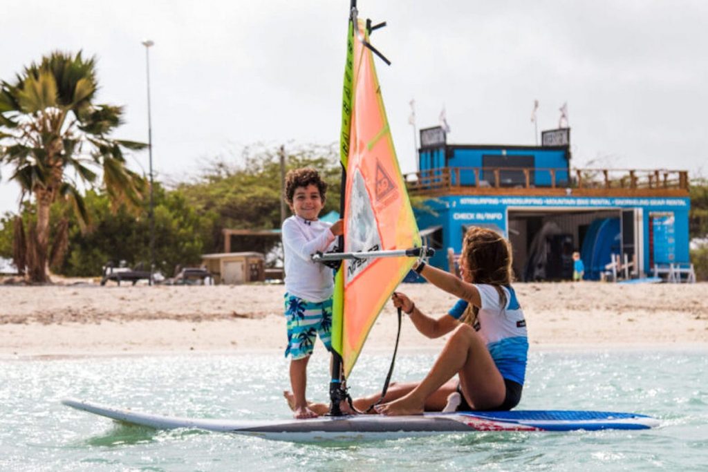 child on windsurfing board at aruba active vacations on hadicurari beach aruba