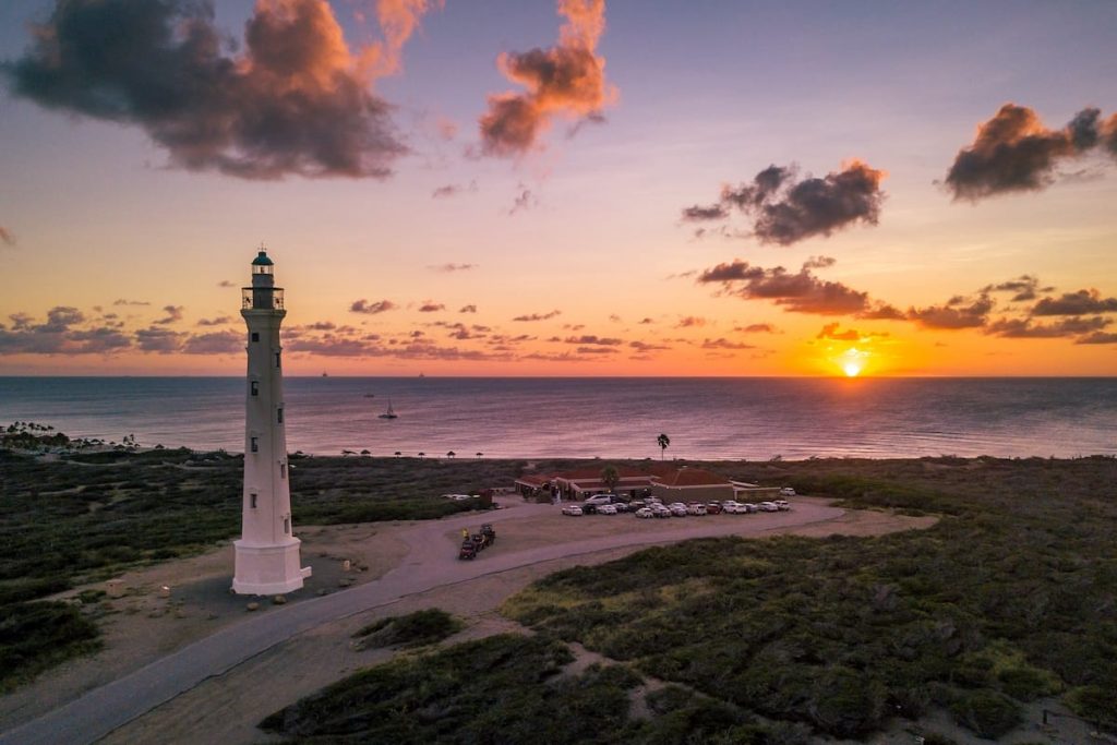 As the sun begins to dip towards the horizon, casting a warm golden glow over the island, the California Lighthouse in Aruba comes alive with an otherworldly beauty.