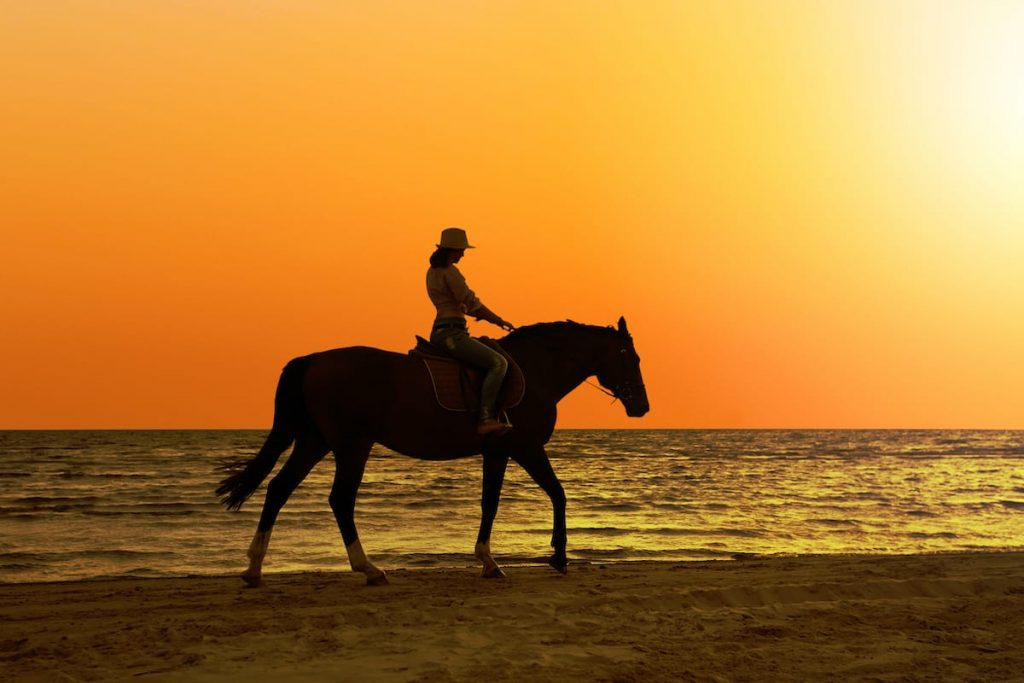A woman riding along the beach during the Arikok National Park Horseback Riding Tour in Aruba.