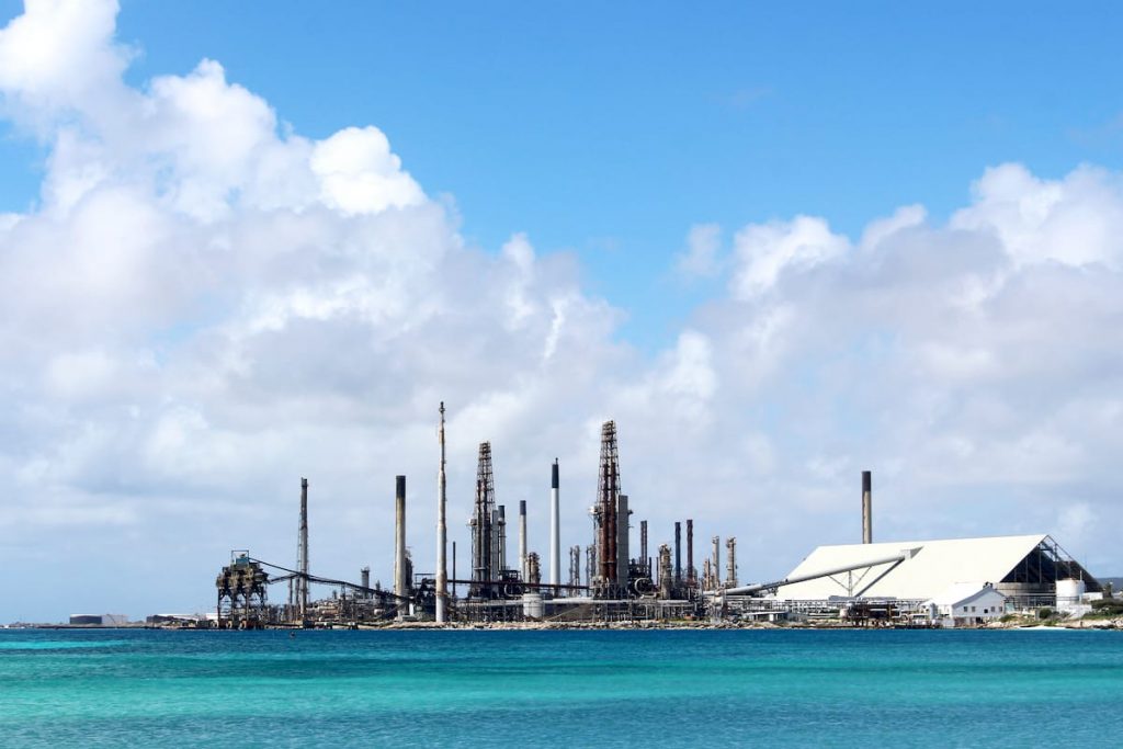 The Aruba oil refinery is an industrial complex against a backdrop of blue skies. The refinery stands as a prominent structure, emanating a sense of power and industry.