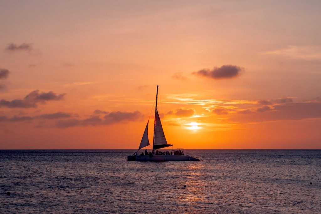 A catamaran sails into the sunset in Aruba, Dutch Caribbean.