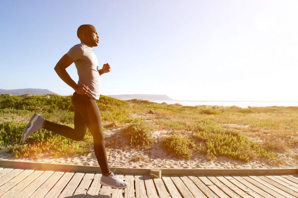 a man jogging on the boardwalk at Malmok Beach in Aruba.