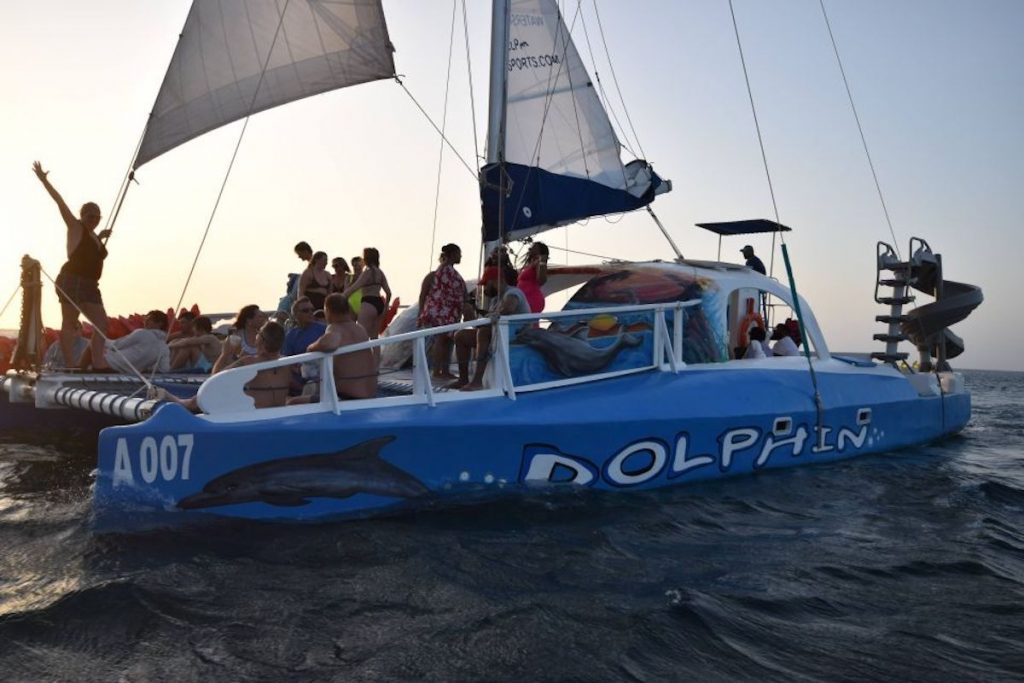 A catamaran named Dolphin cruises the blue waters surrounding Aruba, Dutch Caribbean.