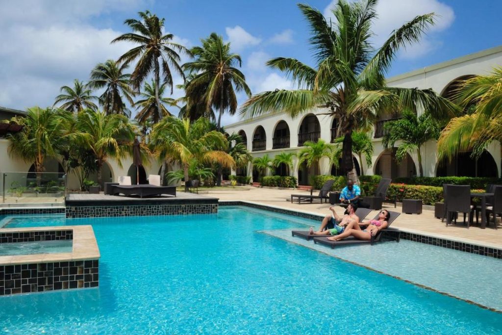 A couple enjoying the pool area at the Talk of the Town Beach Hotel & Beach Club near Oranjestad, Aruba.