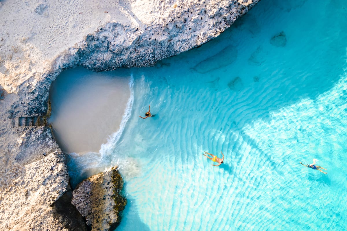 This aerial picture of Tres Trapi presents you with a captivating bird's-eye view of this picturesque snorkeling spot. From above, you can see the shimmering turquoise waters of the Caribbean Sea. Rugged cliffs offer a dramatic contrast against the azure backdrop. The crystal-clear waters reveal the intricate patterns of the coral formations beneath, creating a mosaic of colors and textures.