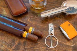 A set of cuban Cohiba cigars laid out on a wooden table.